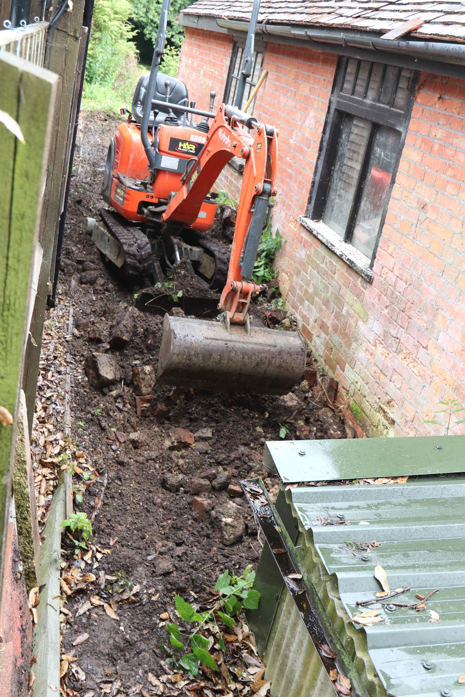 Excavation inside of a 3 meter area in relation to adjacent buildings, could undermine the provisions of the Party Wall Act as may be alleged. This digger is clearly excavating within the prescribed (safe) distance of the Generating Station. The County Archaeologist was informed, to record the event in case of any future subsidence arising. The local authority had drawn the attention of the owners of the Rectory to the Act in a previous planning consent, during a planning application made by Peter Townley, renewed by his daughter Alison Deshayes, before sale to Jill Finn and Nigel Flood. Note the asbestos outbuilding, roof covered by steel sheeting, but the asbestos wall cladding open to the elements. Presumably at some point in the future needing to be disposed of by suitably qualified personnel.